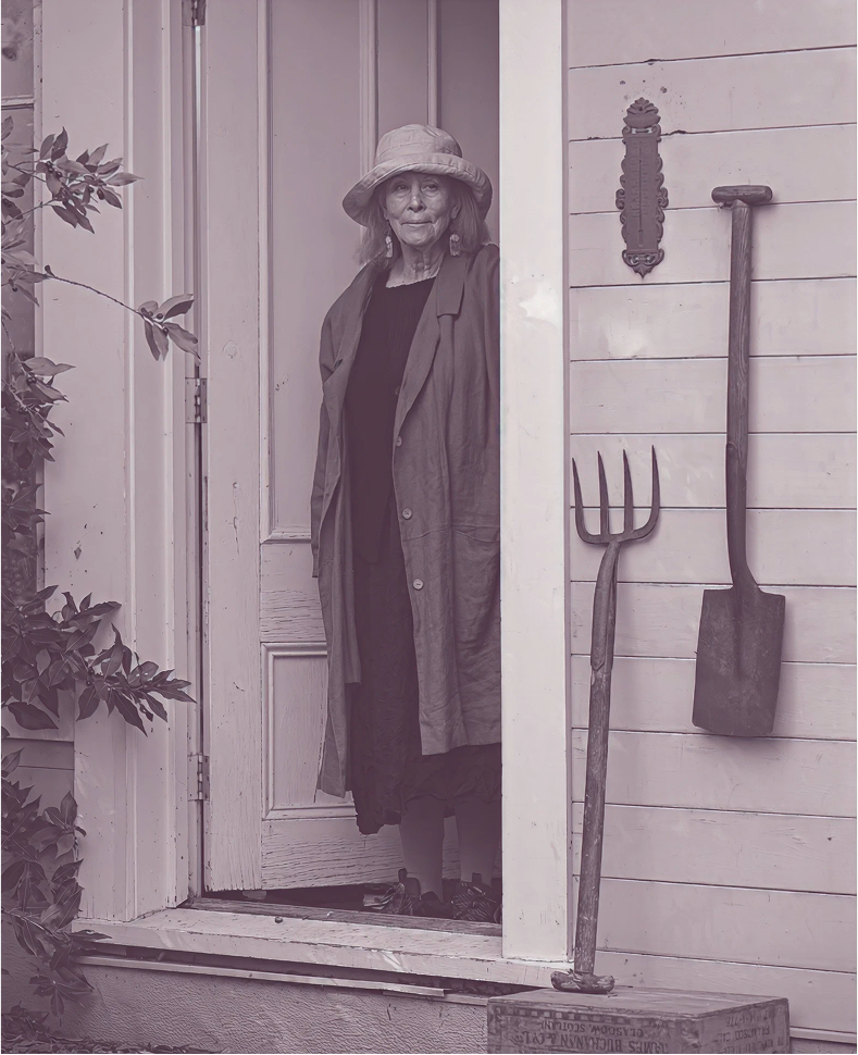 Susan Preston standing in doorway with garden tools